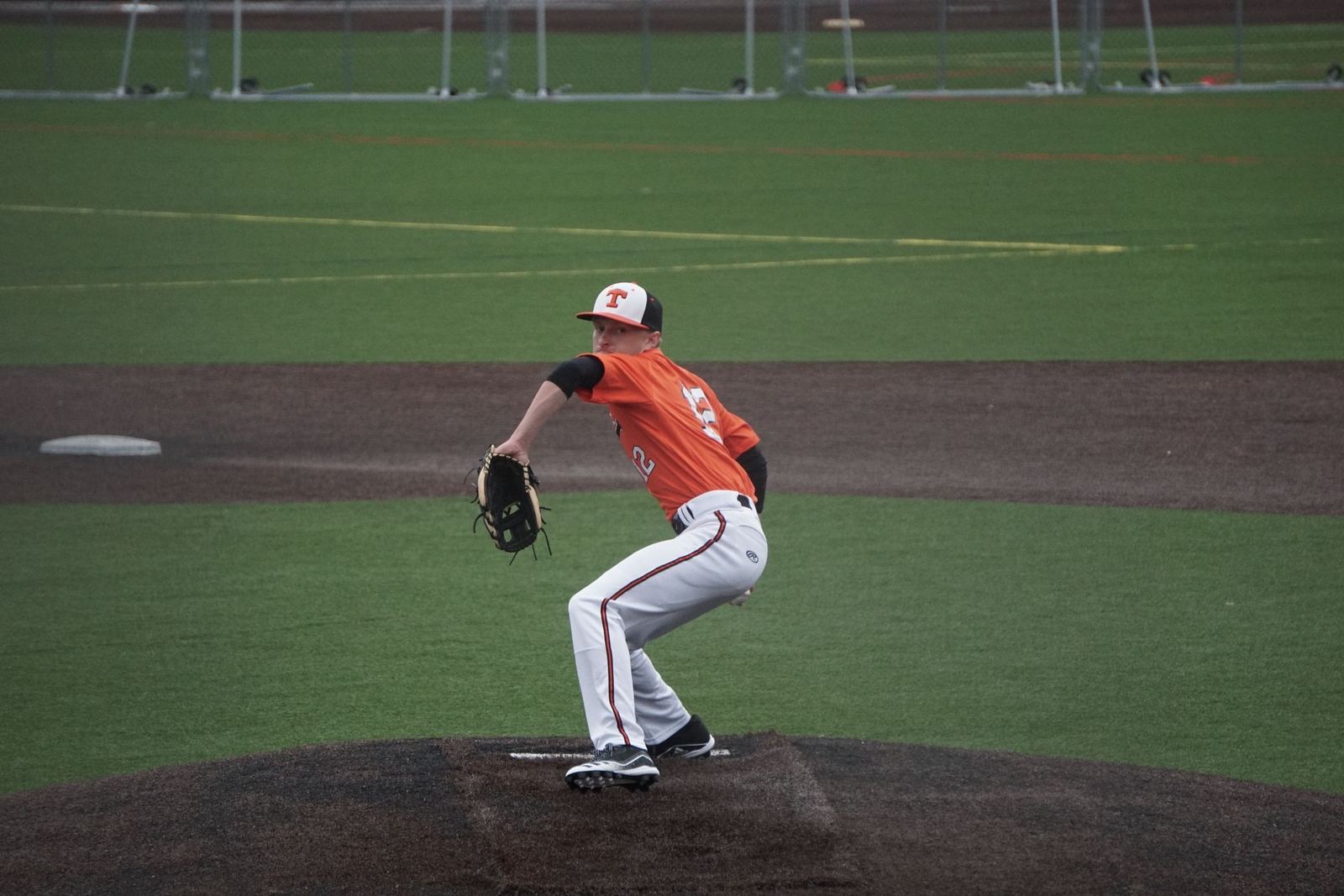 Baseball player pitching in an orange jersey